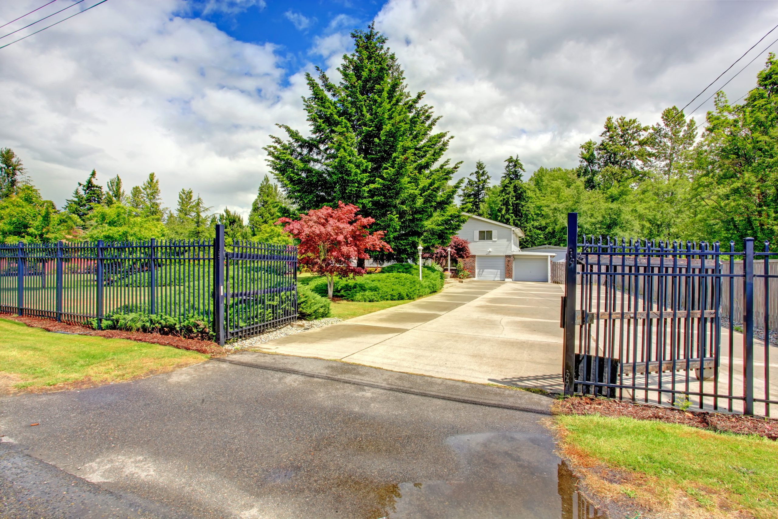 Ornamental steel fence with an automated double driveway gate, one of the line items that raises fence installation cost